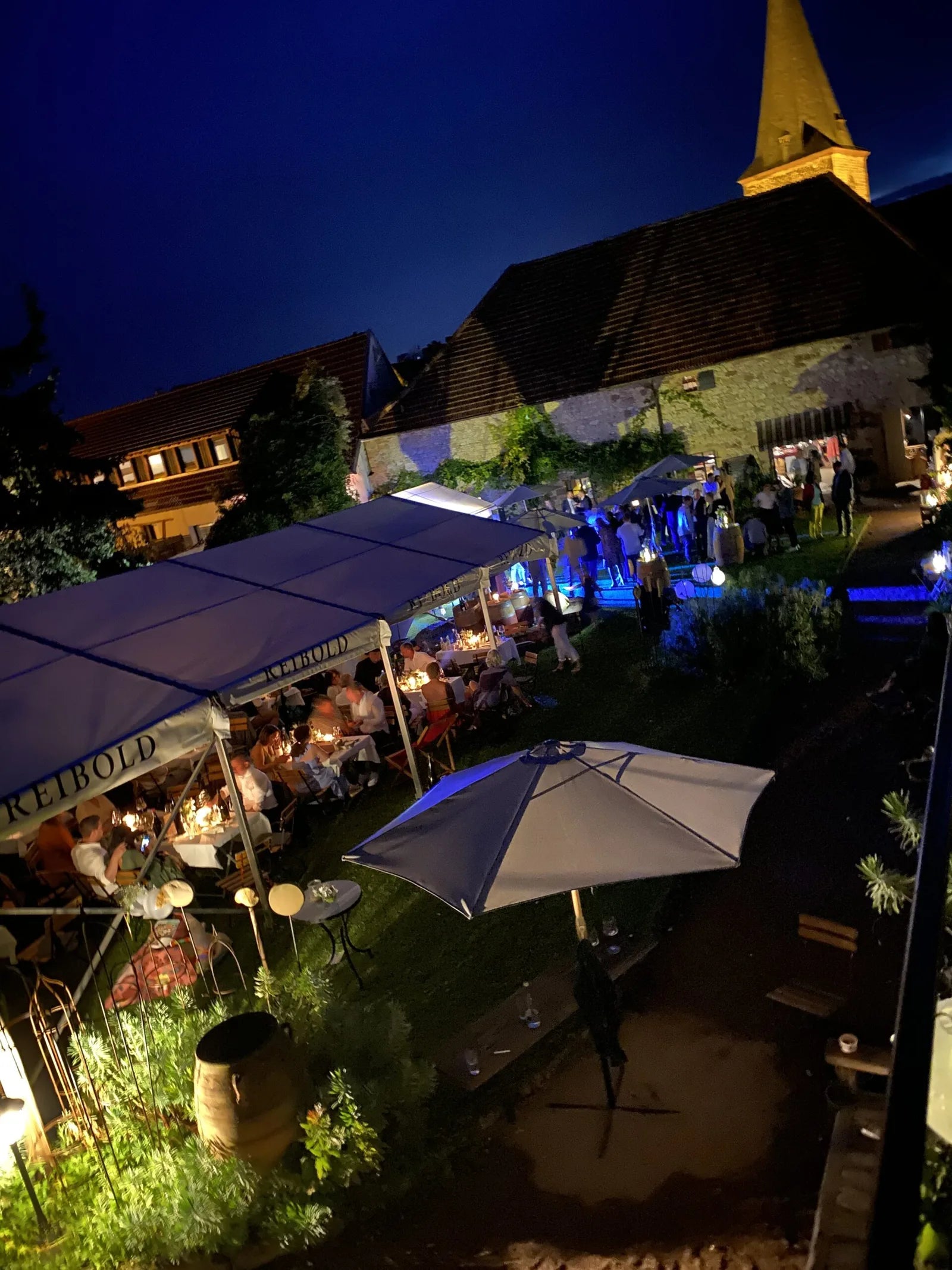 Abendliche Feier im beleuchteten Hof der Palatina Weinbar