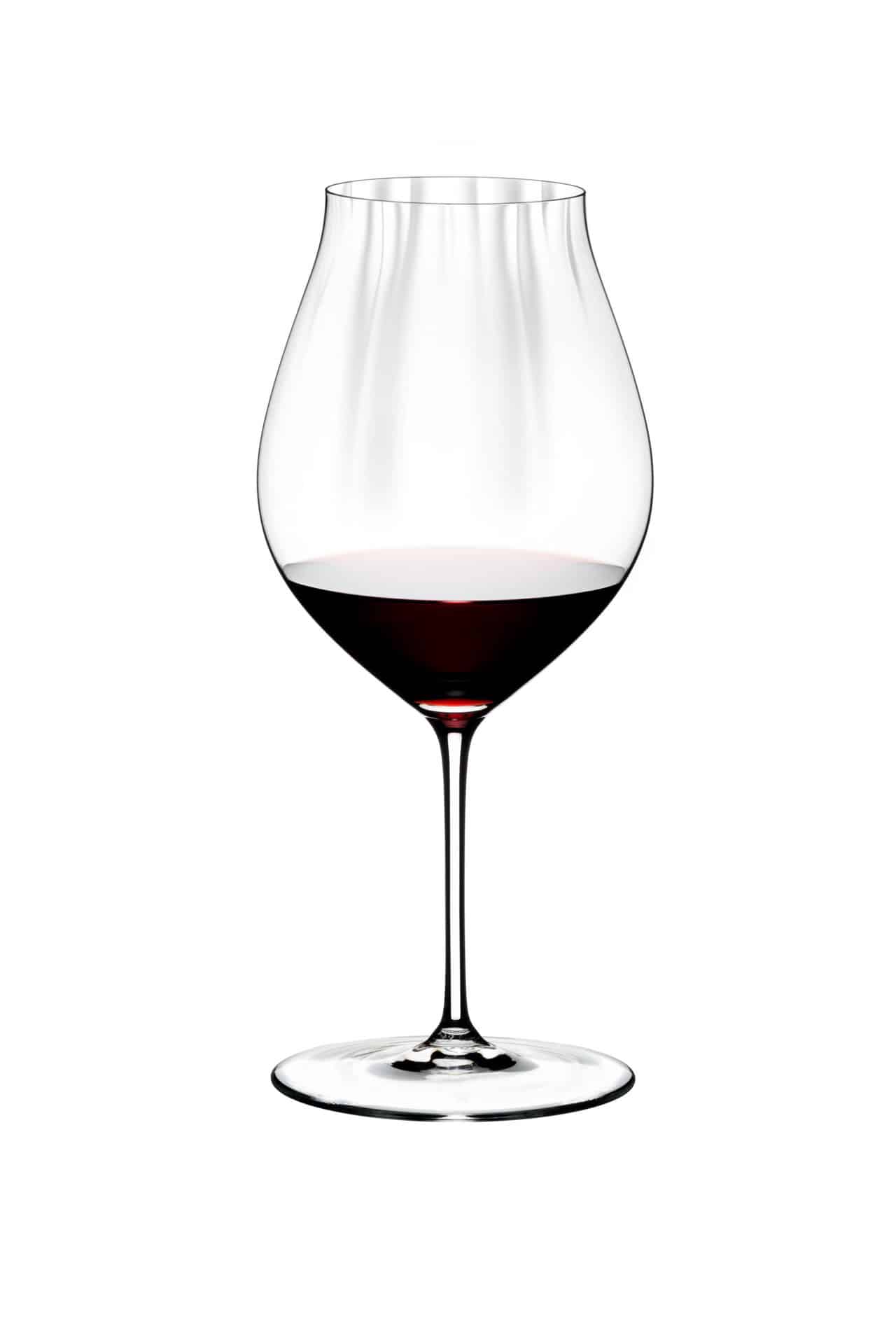 Ein Rotweinglas Riedel Performance aus dem Pinot Noir 4er-Set mit Poliertuch, mit dünnem Stiel, ist zu einem Drittel mit Pinot Noir gefüllt und vor einem schlichten weißen Hintergrund platziert.